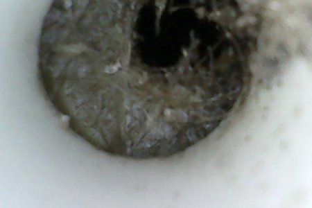 Endoscope view of mostly blocked starboard locker weep hole drain passage. Scope is inserted about 1 foot through starboard weep