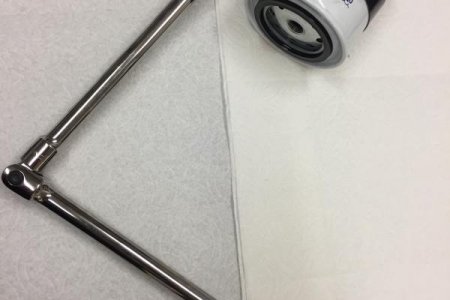 Secondary fuel filter removal tool with friction tape on filter. Note crushed filter.