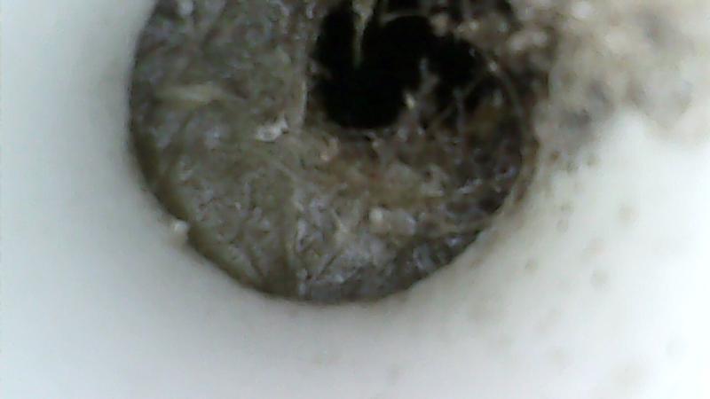 Endoscope view of mostly blocked starboard locker weep hole drain passage. Scope is inserted about 1 foot through starboard weep